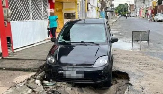 Carro afunda em cratera após asfalto ceder, em cidade do interior; saiba mais