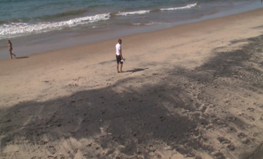 Banhistas convivem com faixa de areia de cor escura entre o Cristo e o Farol da Barra