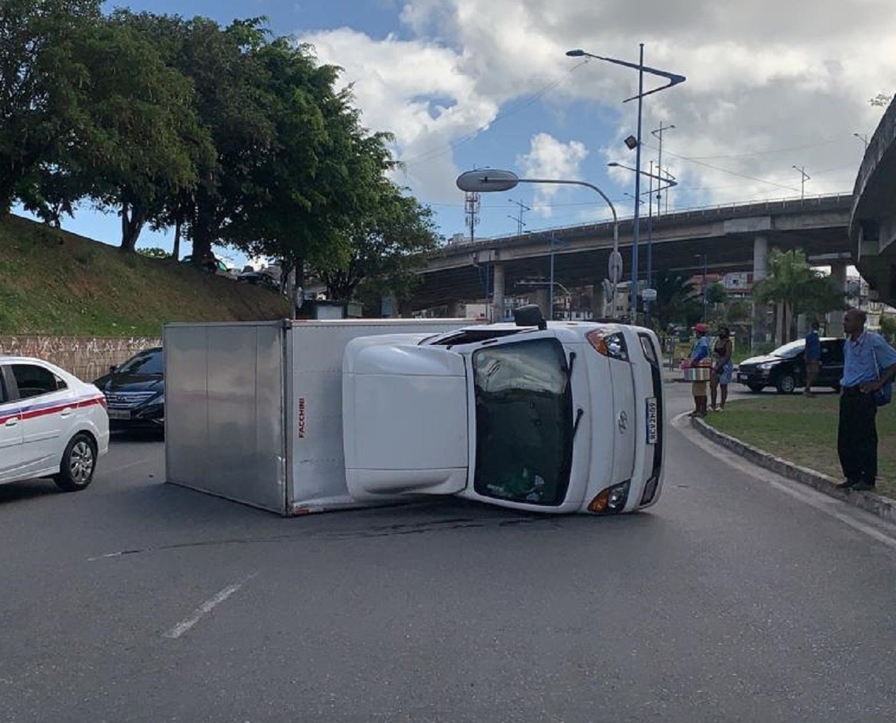 Caminhão baú que fazia transporte de mudança tomba na Rótula do Abacaxi; veja vídeo