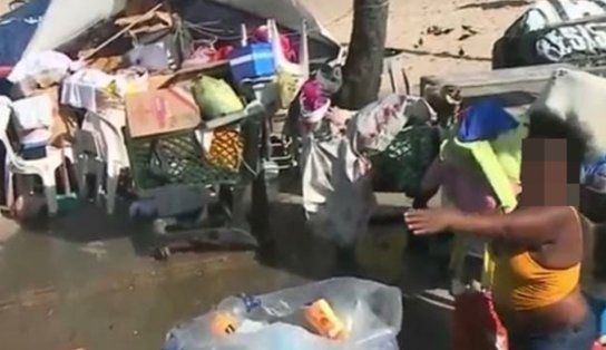 Em protesto contra mau cheiro e sujeira, comerciantes de Itapuã jogam itens de moradora em situação de rua no chão